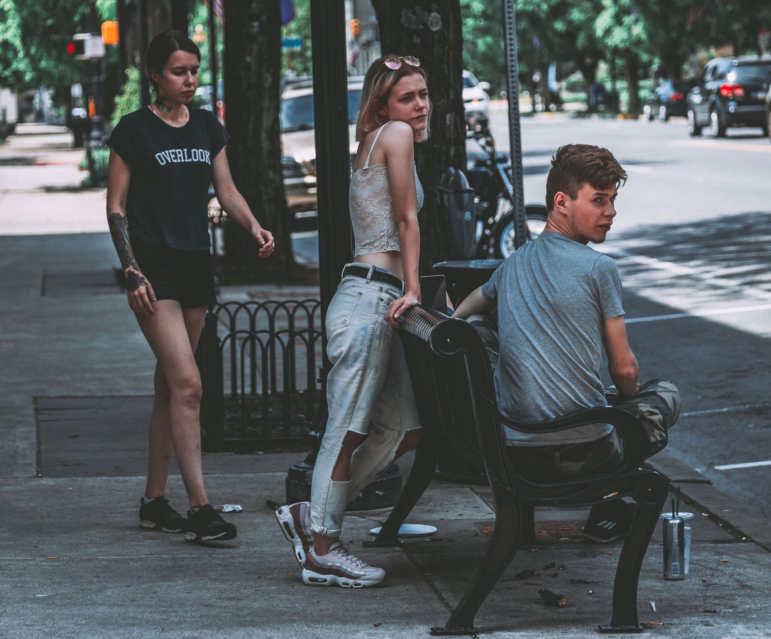 three person staying on sidewalk